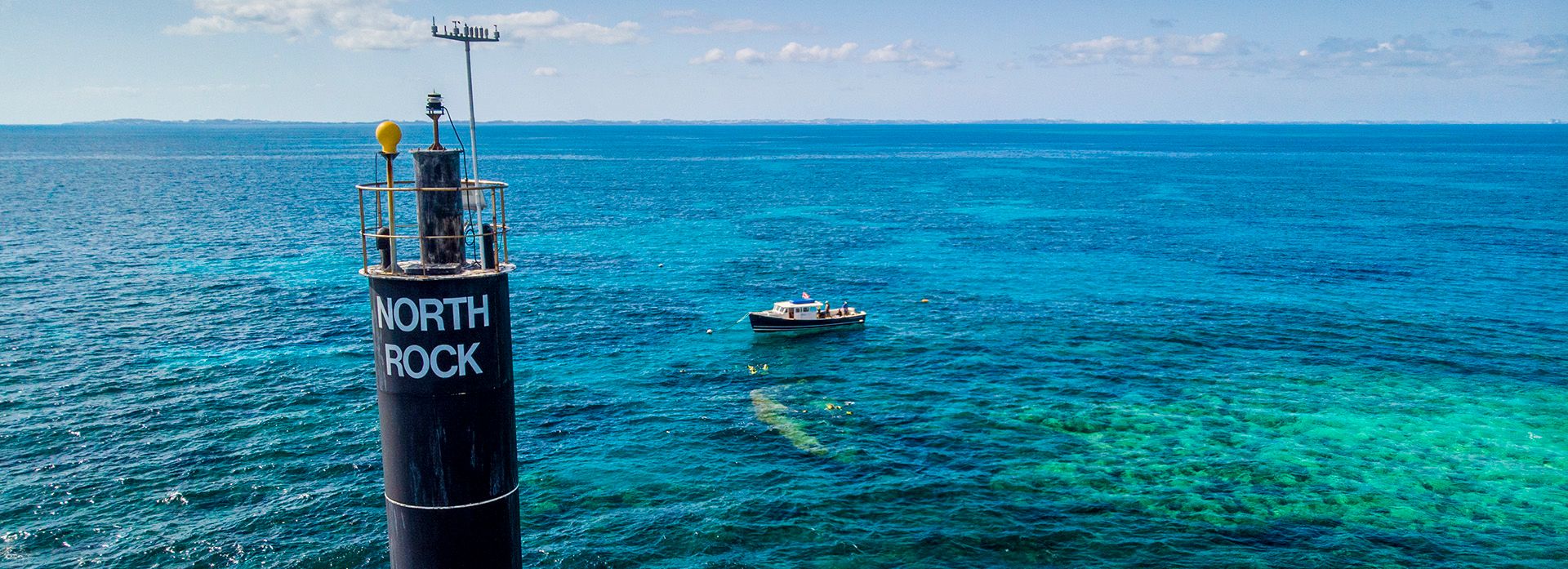 Image of north rock marker and a boat