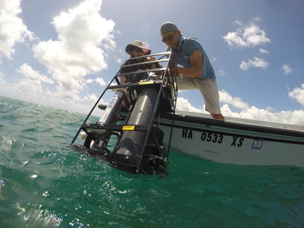 Scientists deploy instruments off the side of a boat